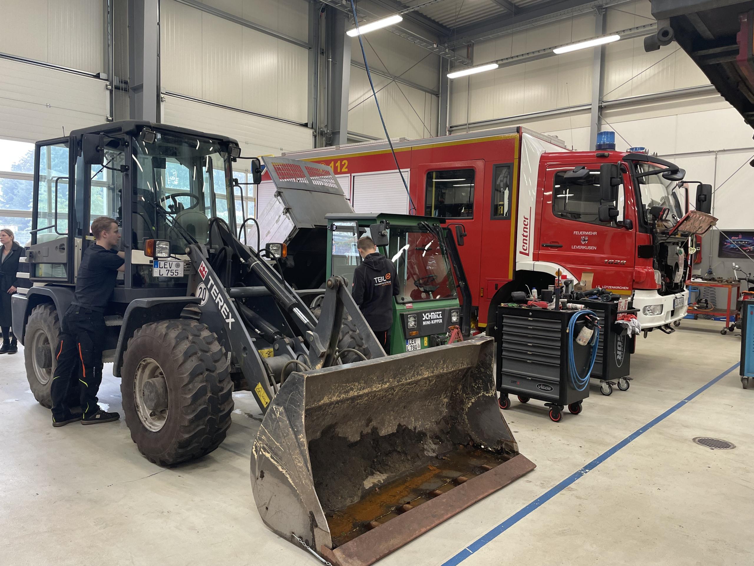 Werkstatt mit Feuerwehrfahrzeug und Bagger